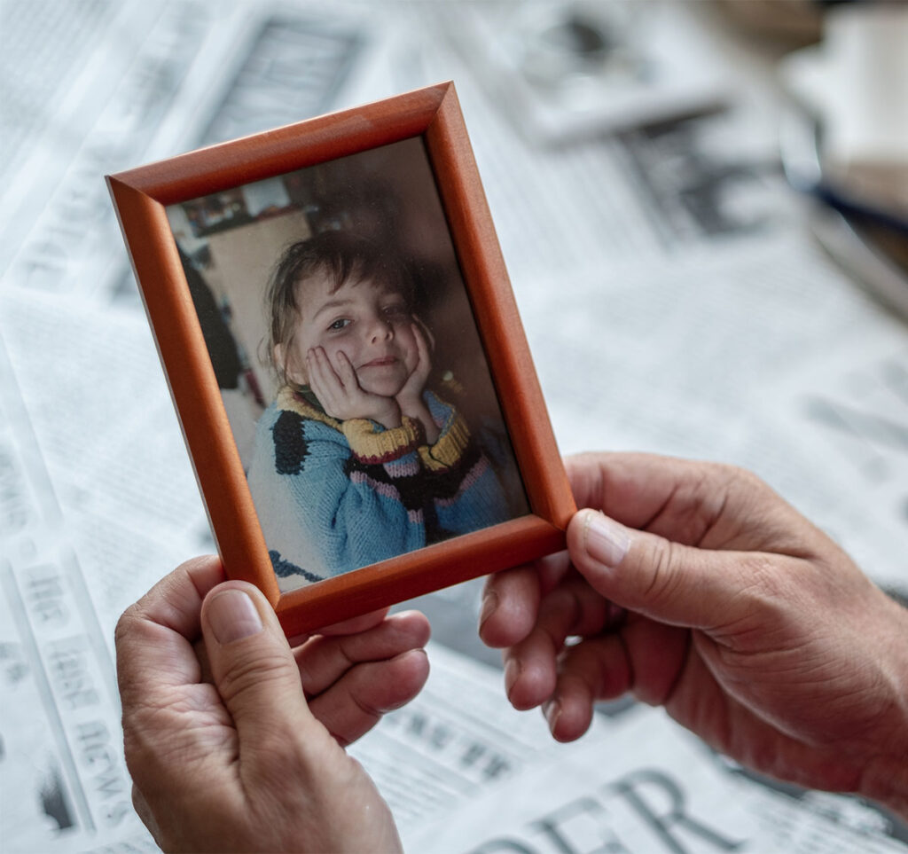 Hände halten ein eingerahmtes Kinderfoto