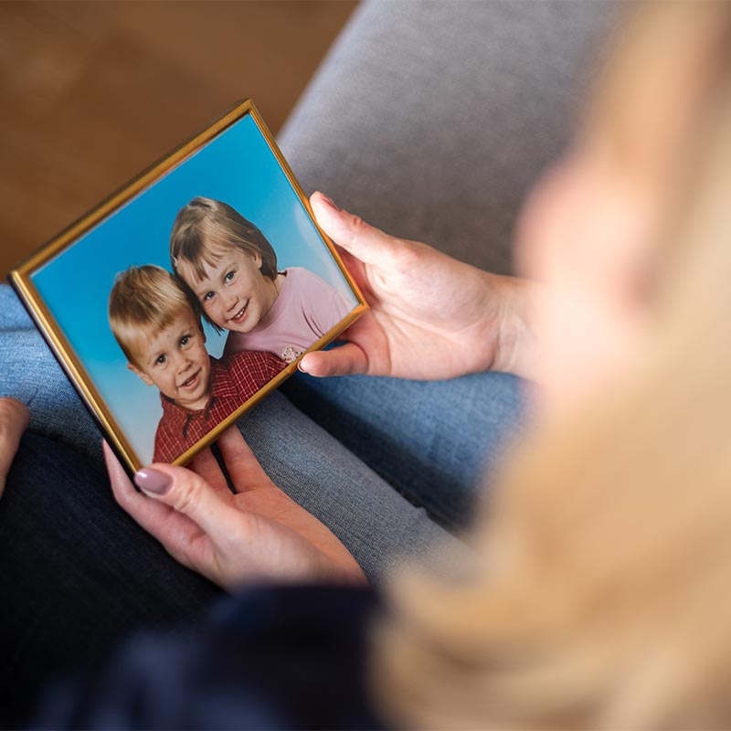 Schulterblick auf ein gerahmtes Kinderfoto eines Geschwisterpaares